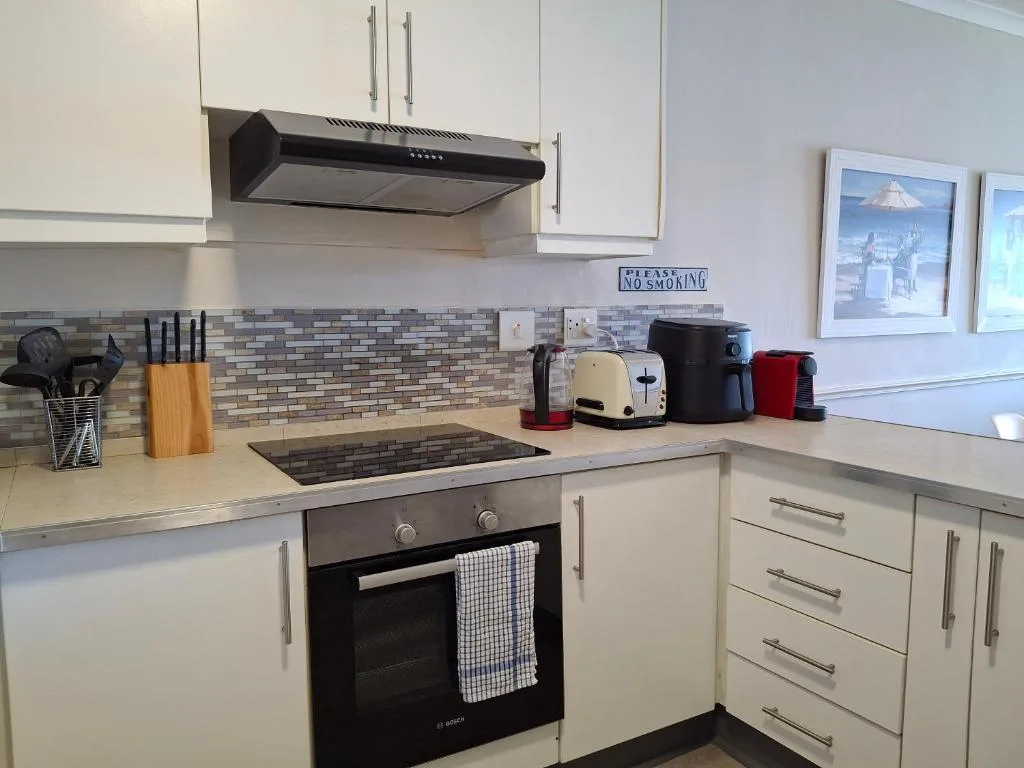 Modern white kitchen with stove, cooktop, and counter appliances