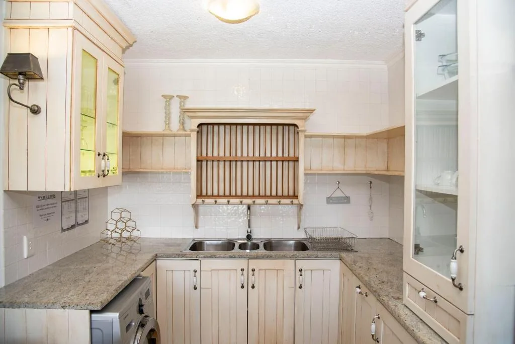 Bright kitchen with cream cabinetry, granite countertops, and modern appliances
