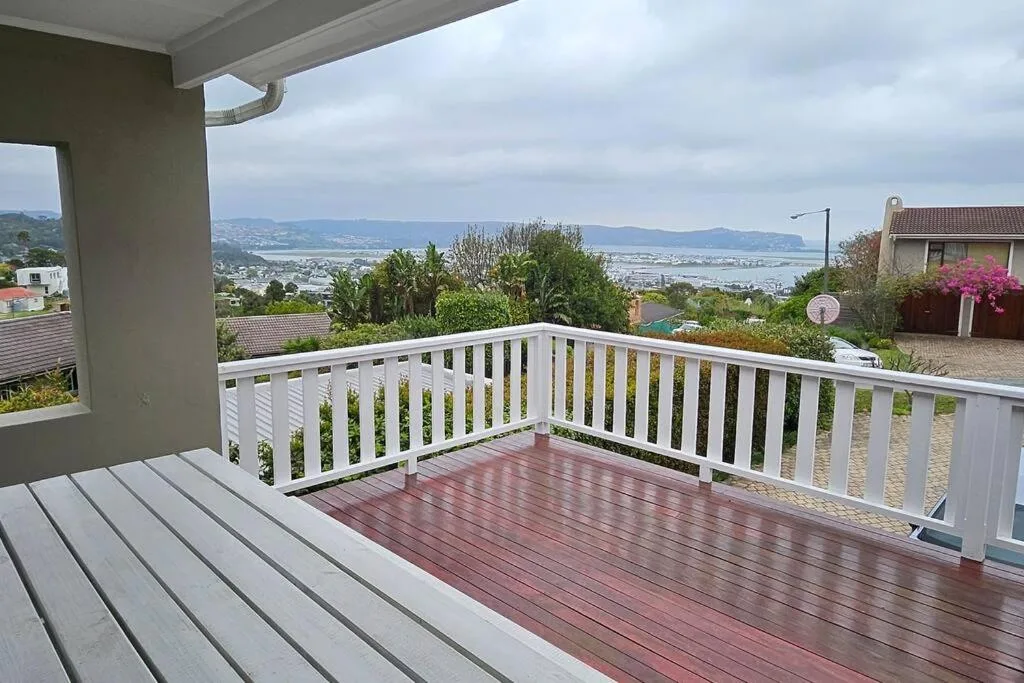 Spacious wooden deck with white railings overlooking scenic landscape view