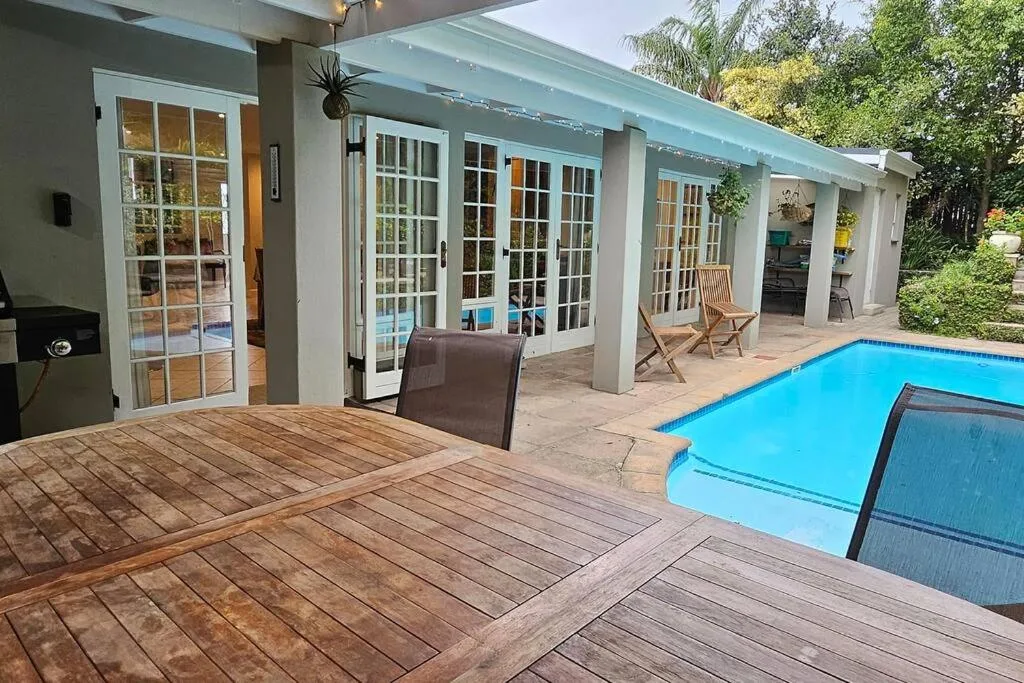 Wooden deck with pool and modern house with glass doors