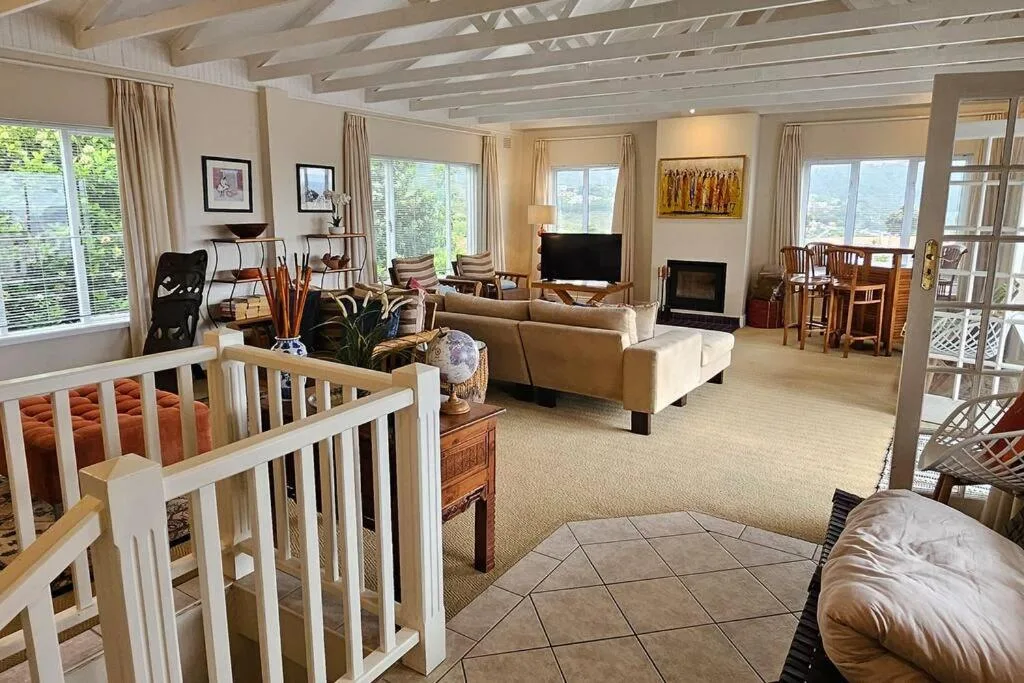 Spacious open-plan lounge with comfortable seating, fireplace, and large windows
