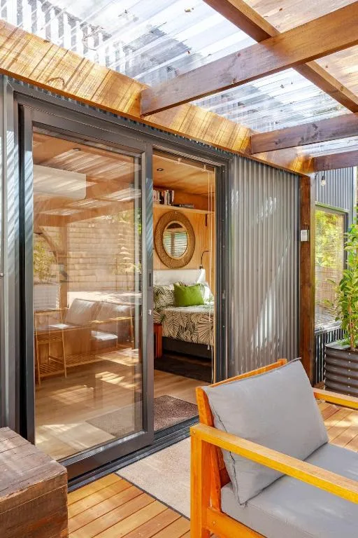 Wooden deck with lounge chairs overlooking modern glass pod bedroom