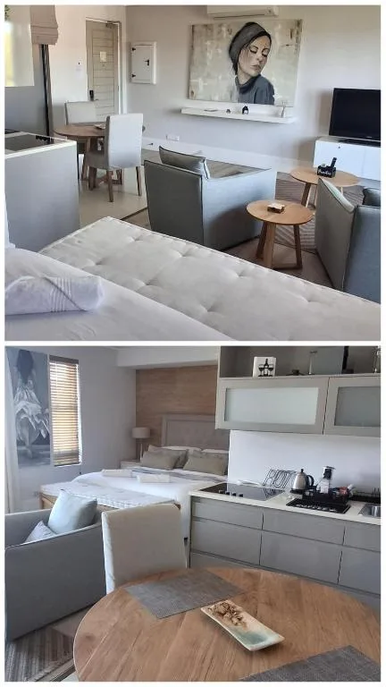 Open-plan lounge with sofa, TV, and bed visible in background