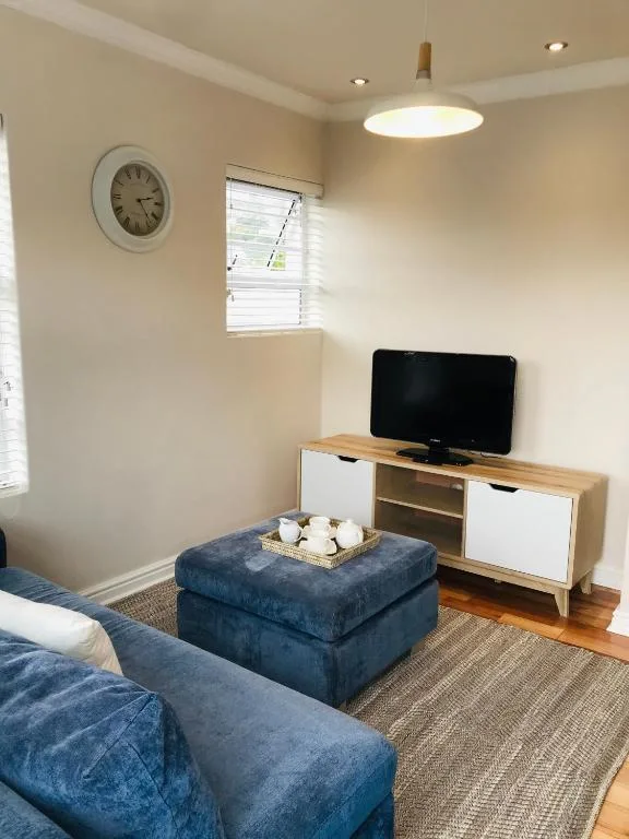 Cozy lounge with blue sofa, TV unit, and modern pendant lighting