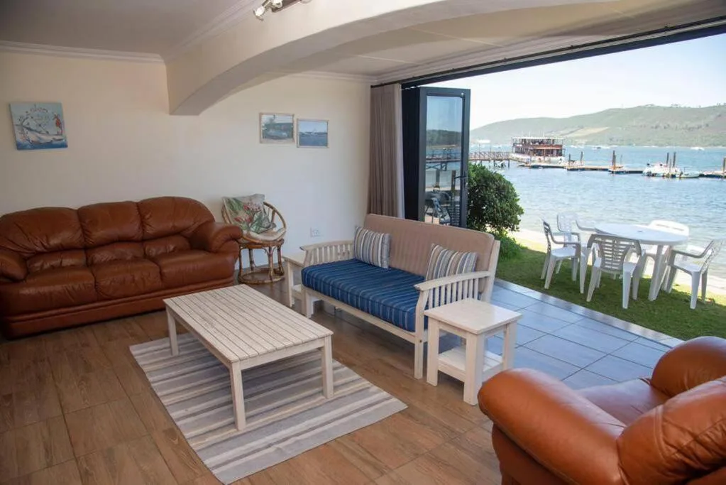 Open-plan lounge with leather sofa, seating area, and lagoon views