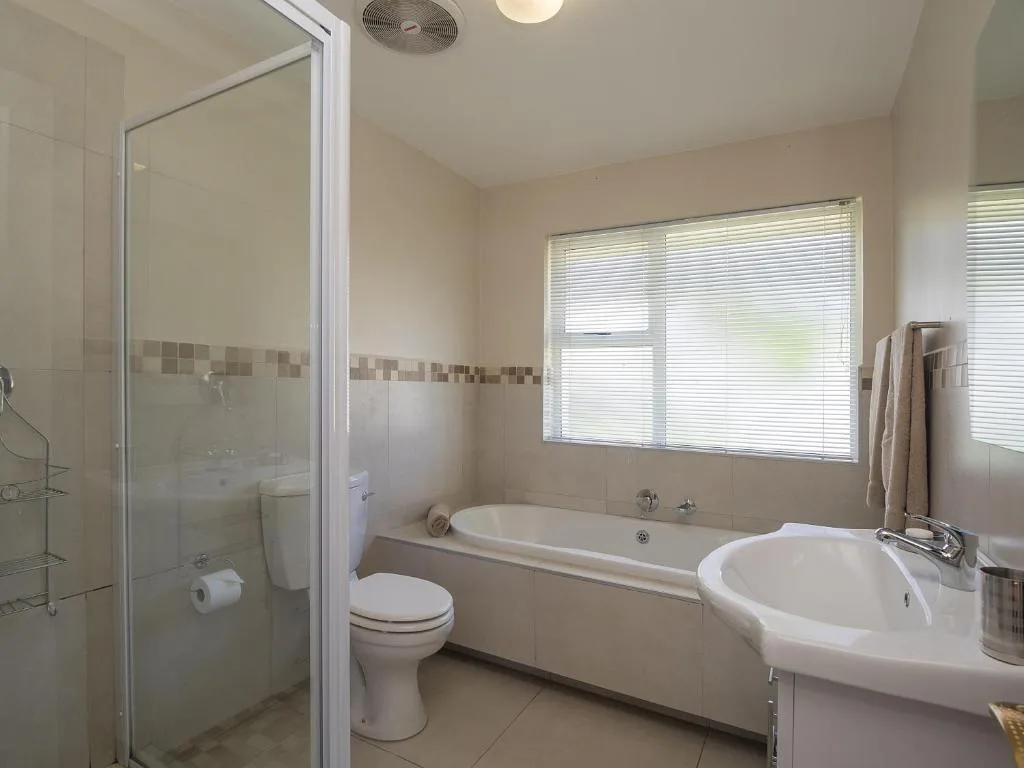 Modern bathroom with shower, bathtub, toilet, and round sink basin