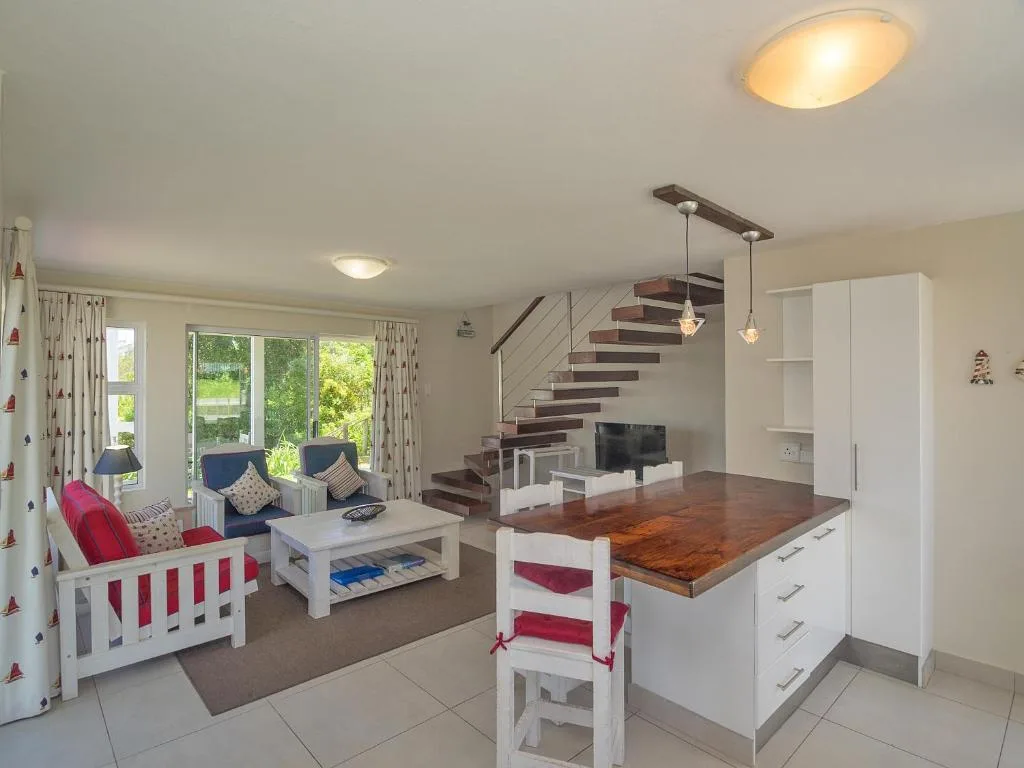 Open-plan living area with comfortable seating and modern staircase design