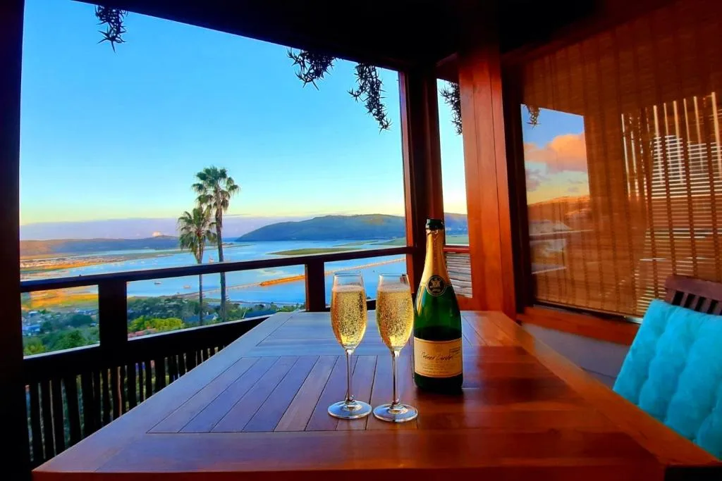 Sunset deck with champagne glasses overlooking Knysna lagoon and mountains