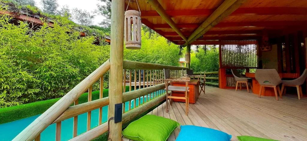 Wooden deck with seating area overlooking lush gardens and pool
