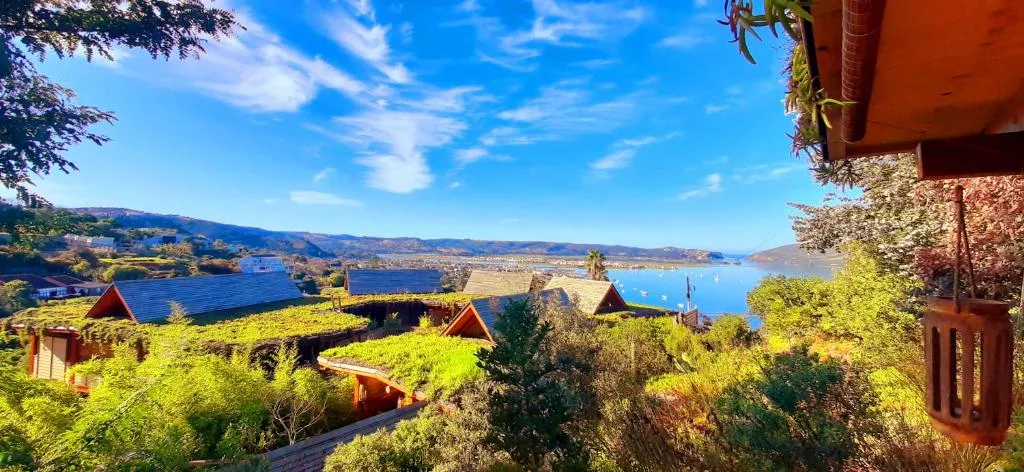 Stunning lagoon vista with lush green hills and red-roofed cottages