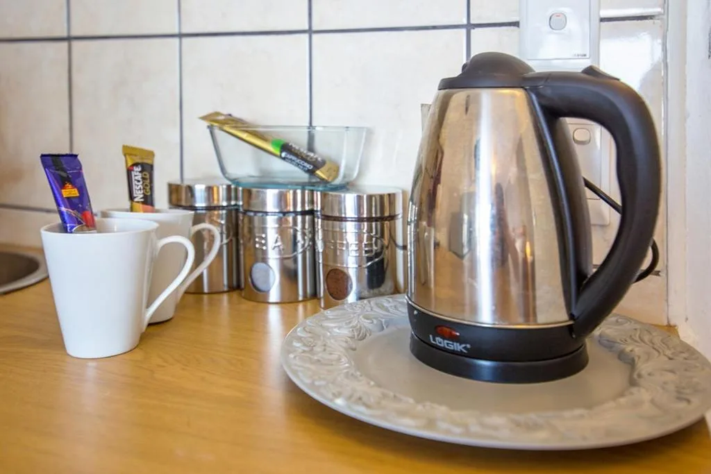 Kitchen counter with electric kettle, mugs, and coffee supplies