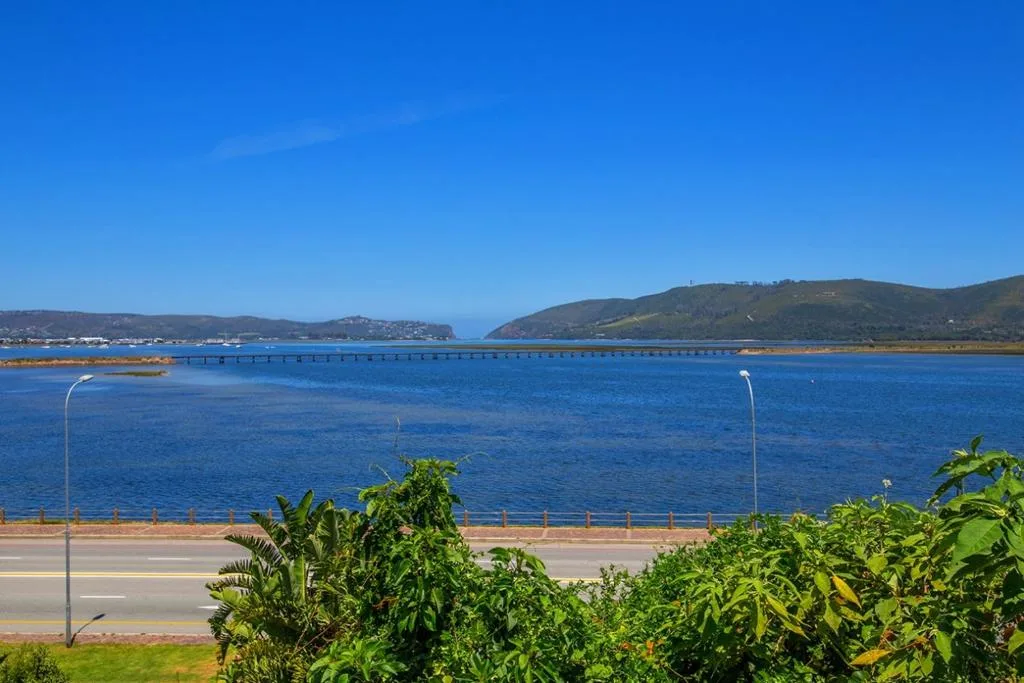 Scenic lagoon vista with bridge, mountains, and clear blue water