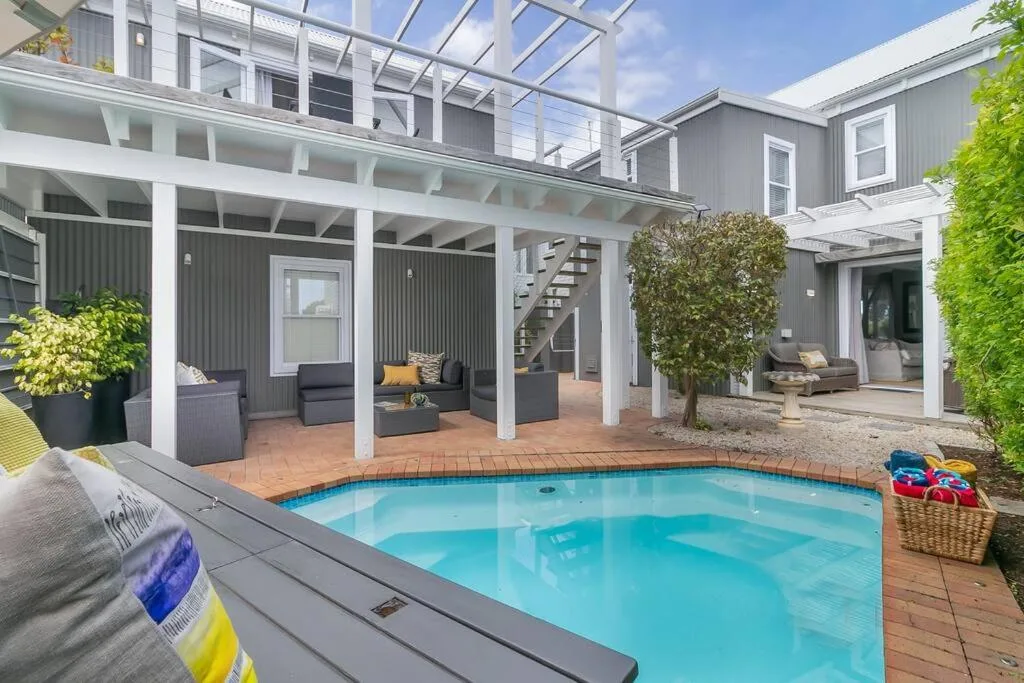 Sparkling swimming pool with covered deck and lounging area