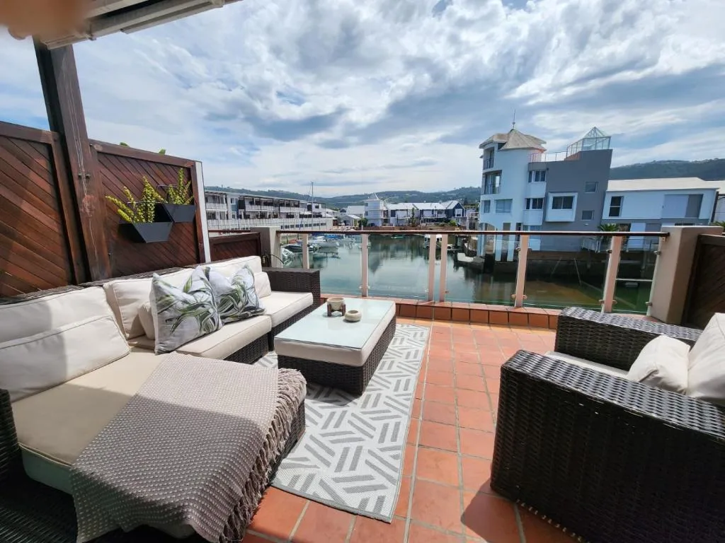 Waterfront deck with lounge seating overlooking Knysna lagoon and mountains