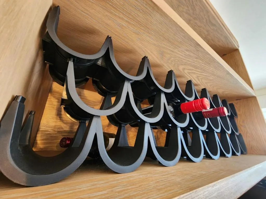 Wine holder with black and grey U-shaped cradles on wooden shelf