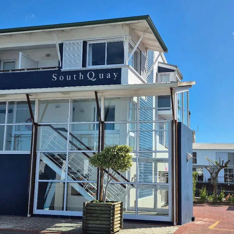 Modern waterfront apartment building with SouthQuay signage and glass facade