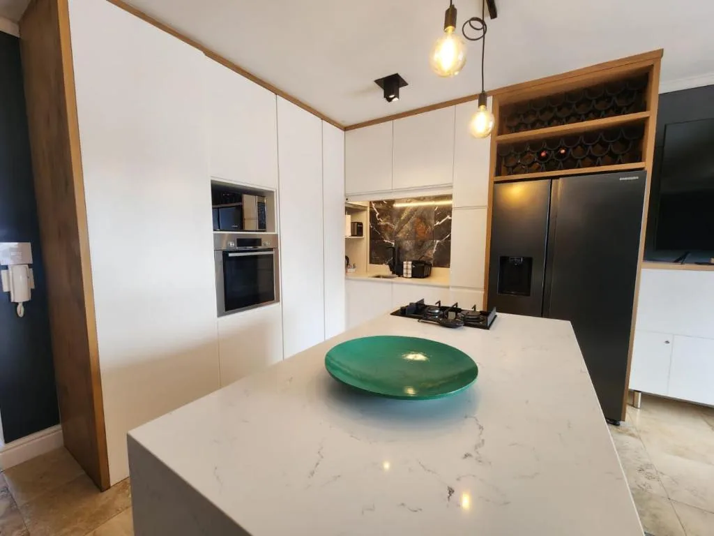Modern kitchen with white cabinetry, gas cooktop, and black appliances