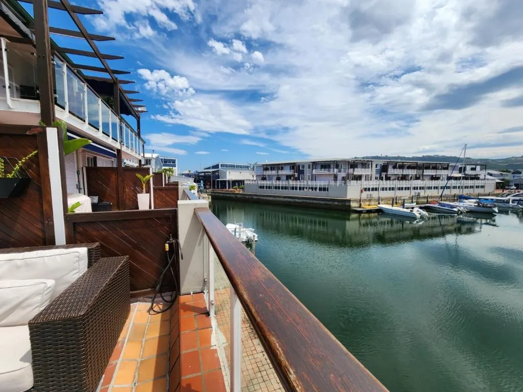 Waterfront deck overlooks Knysna lagoon with boats and coastal architecture