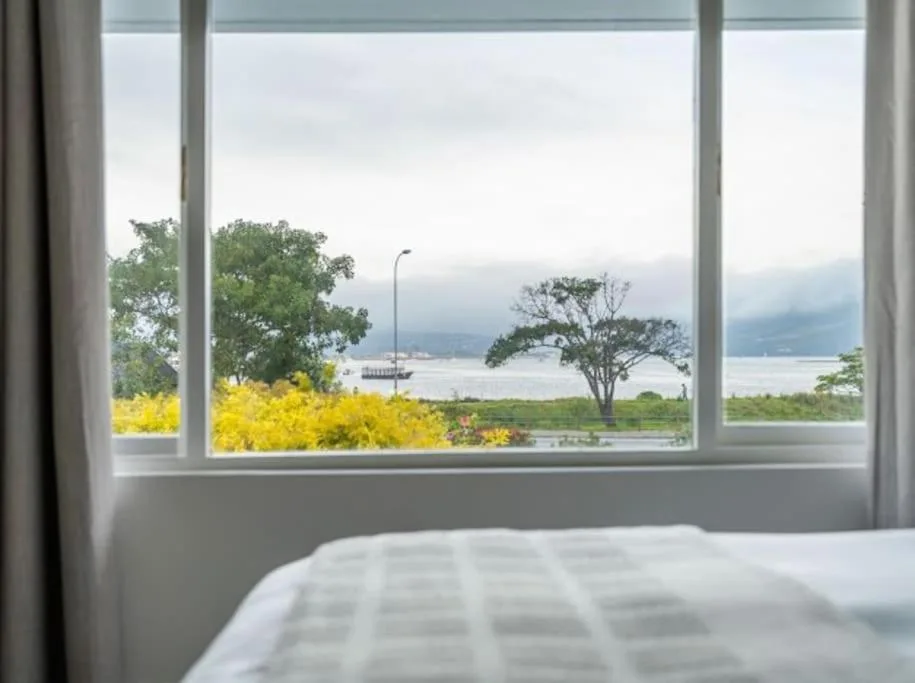 Bedroom with lagoon and mountain views through large windows