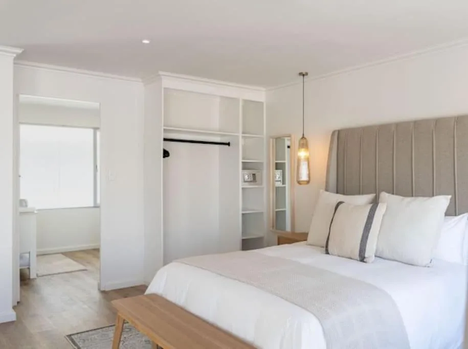 Spacious bedroom with queen bed, ensuite bathroom, and built-in wardrobes