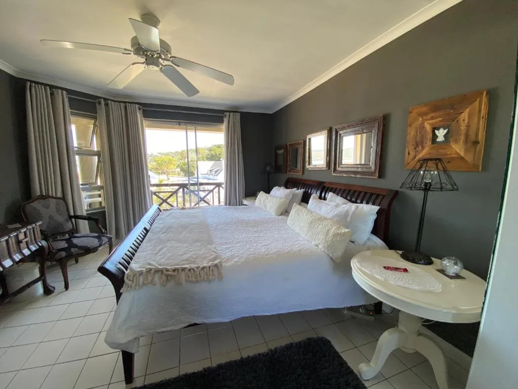 Spacious bedroom with king bed, deck access, and garden views