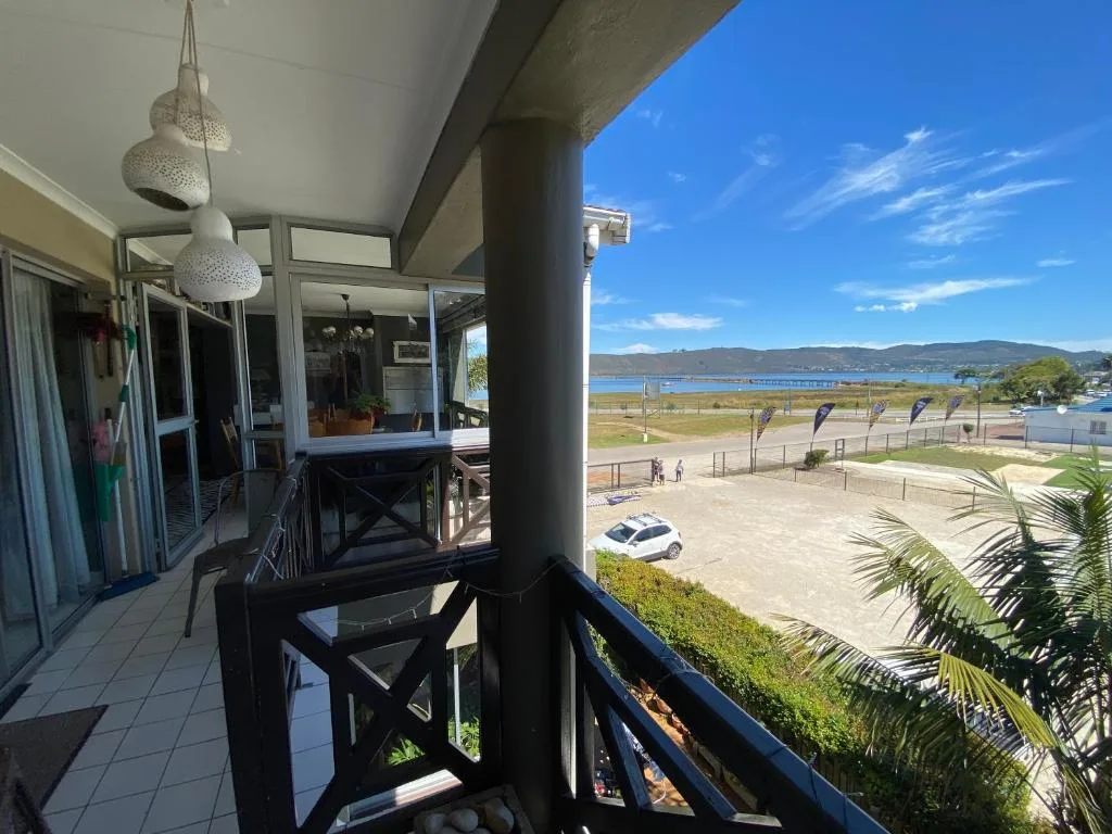 Covered deck with ocean and mountain views, beach access visible below