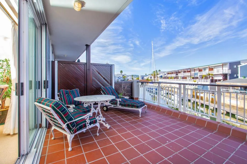 Spacious balcony with striped chairs overlooking Knysna waterfront and marina
