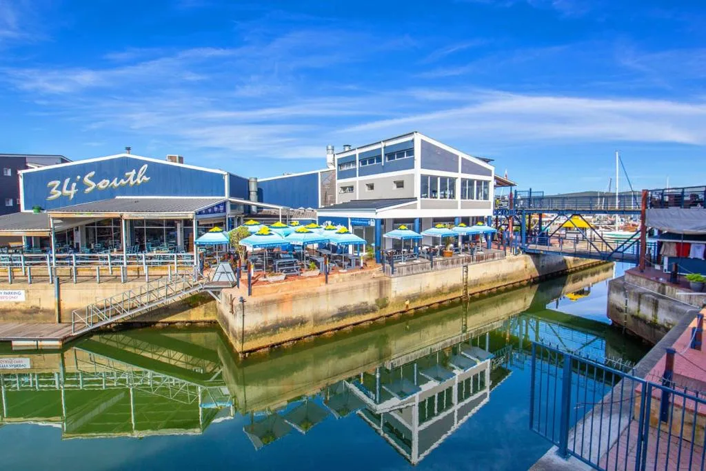 Waterfront restaurant and marina with blue umbrellas overlooking Knysna lagoon
