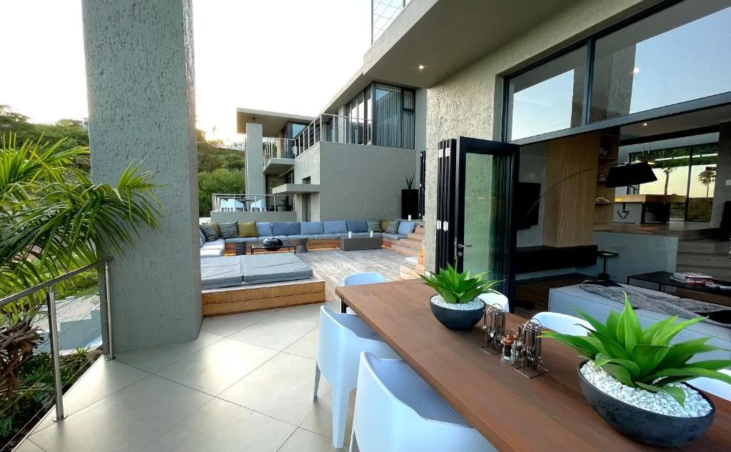 Modern multi-level deck with built-in seating, potted plants, and garden views