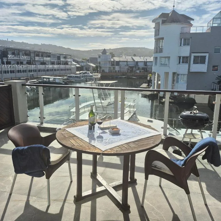 Waterfront deck with dining table, chairs, and lagoon views