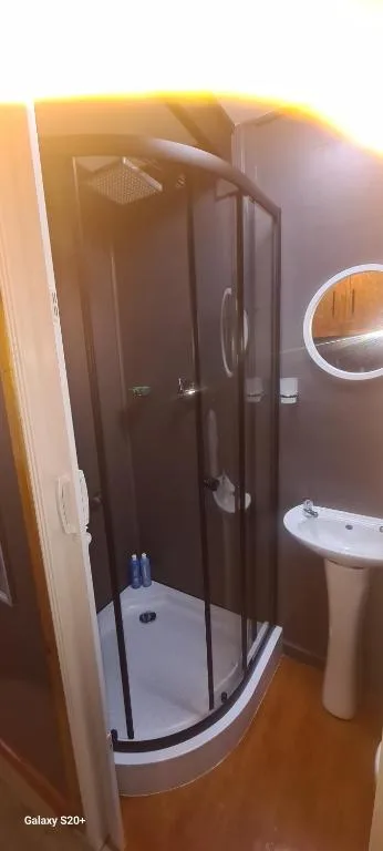 Modern bathroom with corner shower enclosure and pedestal sink