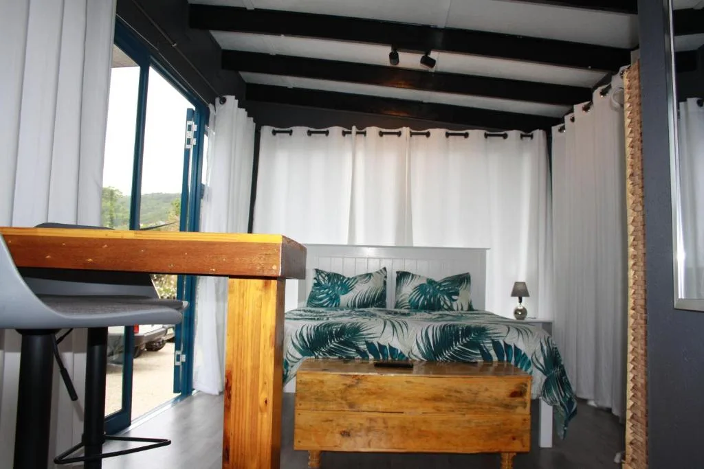 Modern bedroom with tropical patterned bedding and wooden bed frame