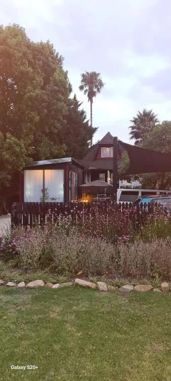 Modern dark cottage with garden surrounded by lavender and palm trees