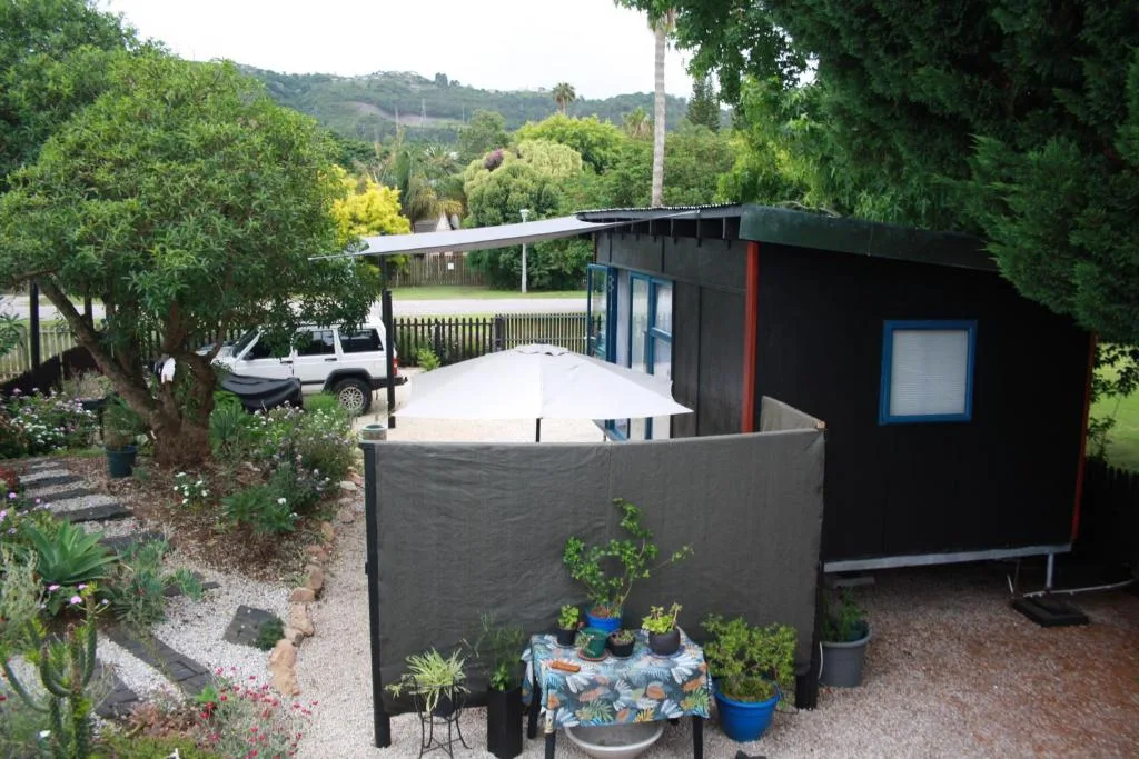 Modern black studio cabin with garden surroundings and mountain views in background