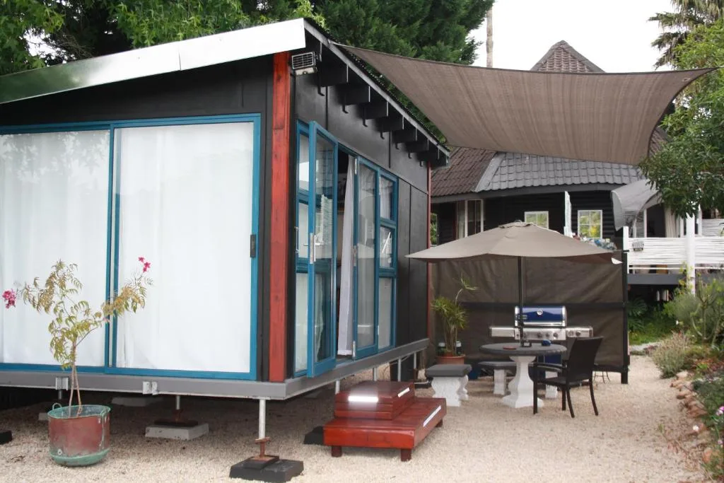 Modern studio with blue-framed windows and shaded outdoor seating area