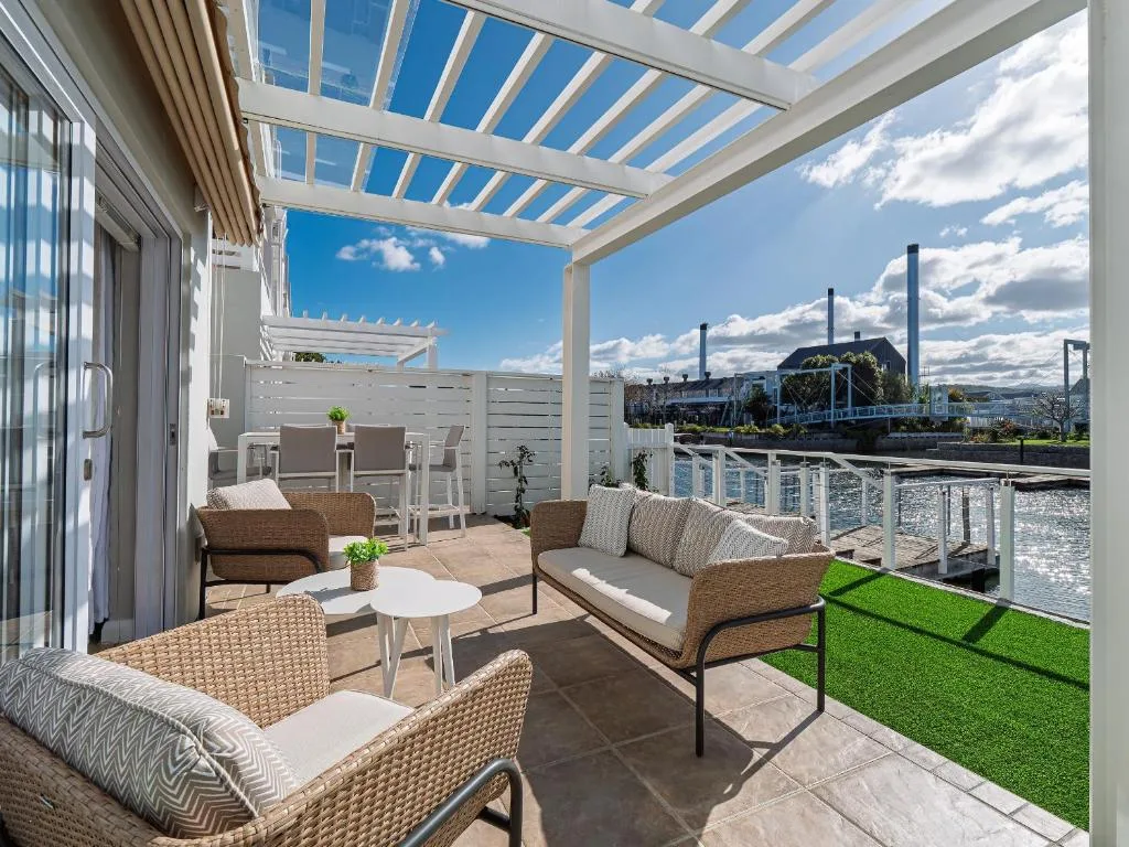 Spacious covered patio with lounge seating overlooking lagoon and mountains