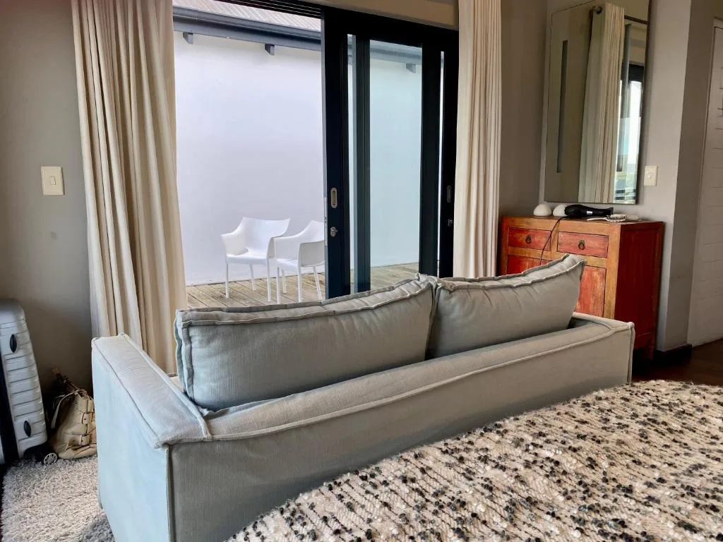 Modern lounge with gray sofa overlooking deck and seating area