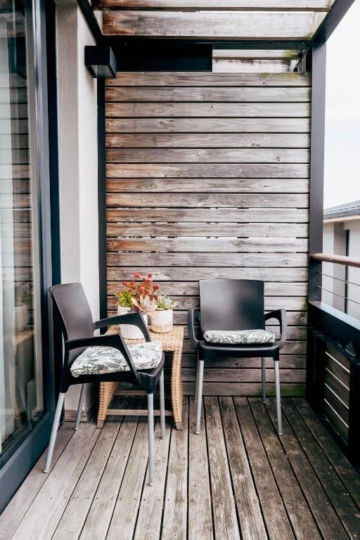 Wooden deck with two black chairs and potted plant decoration