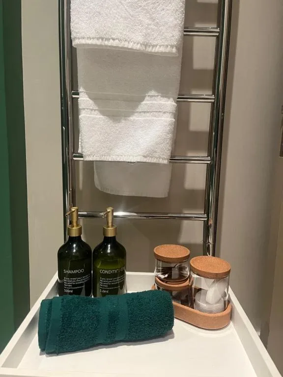 Bathroom amenities including shampoo, conditioner, towels and toiletries displayed neatly