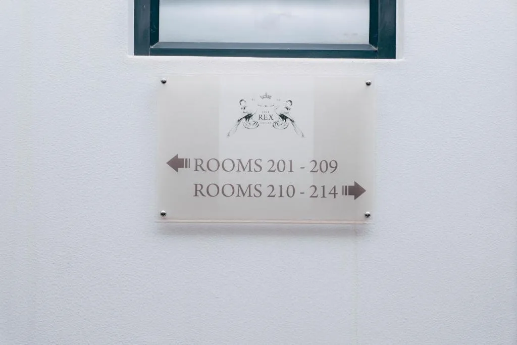 Interior wayfinding sign directing guests to room numbers at property