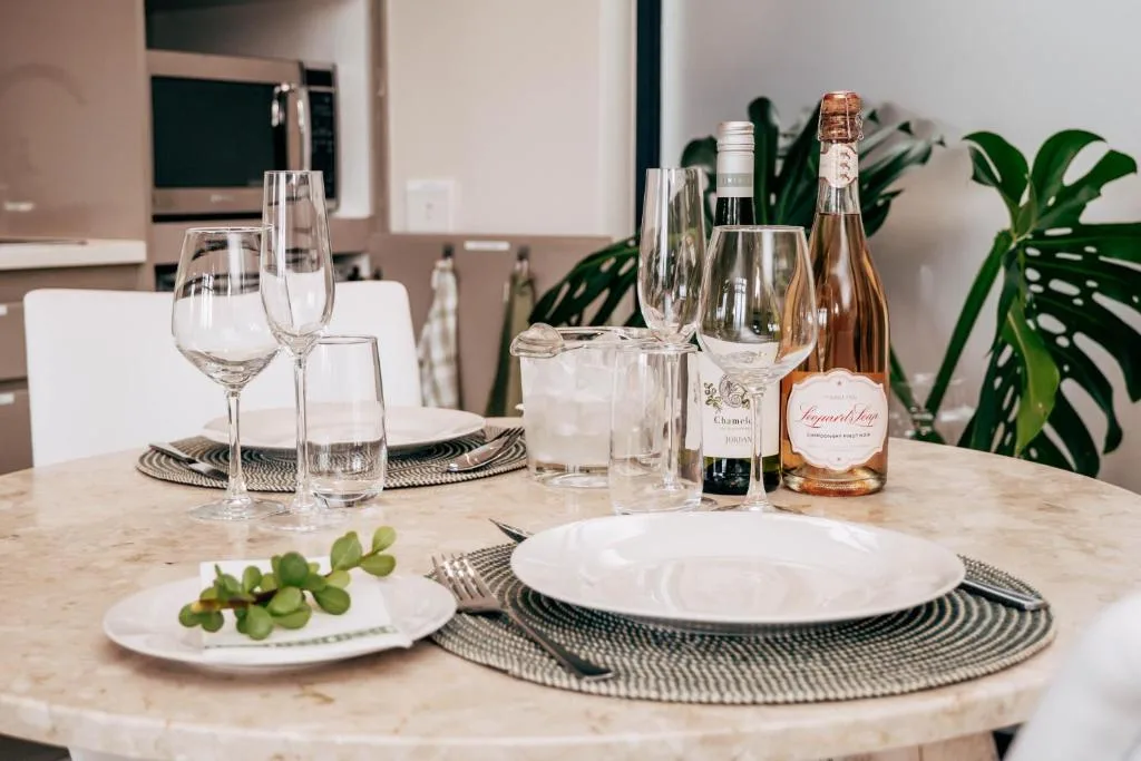 Elegant dining table set with wine glasses, plates, and fresh flowers indoors