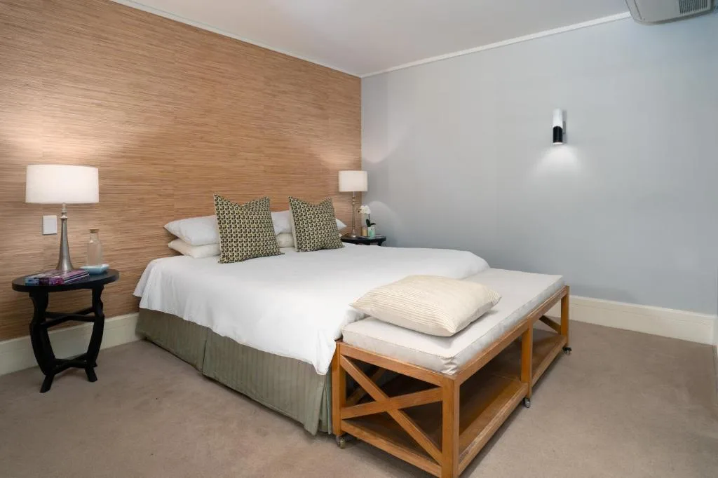 Modern bedroom with queen bed, wood accent wall, and bedside lamps