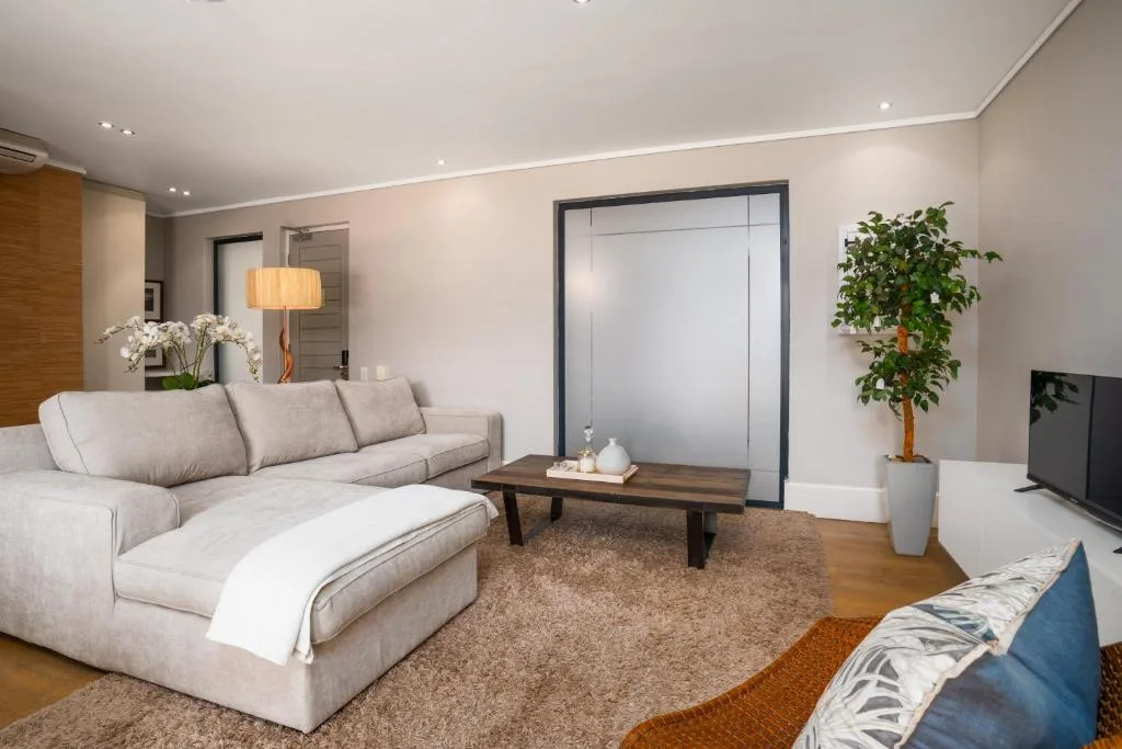 Spacious modern lounge with cream sectional sofa and wooden coffee table