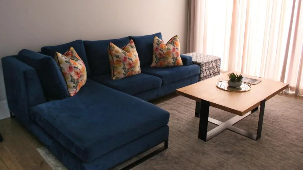 Modern lounge with blue sectional sofa and wooden coffee table