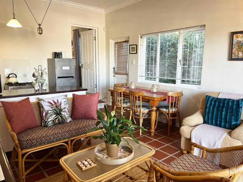 Open-plan lounge and dining area with rattan furniture and garden views
