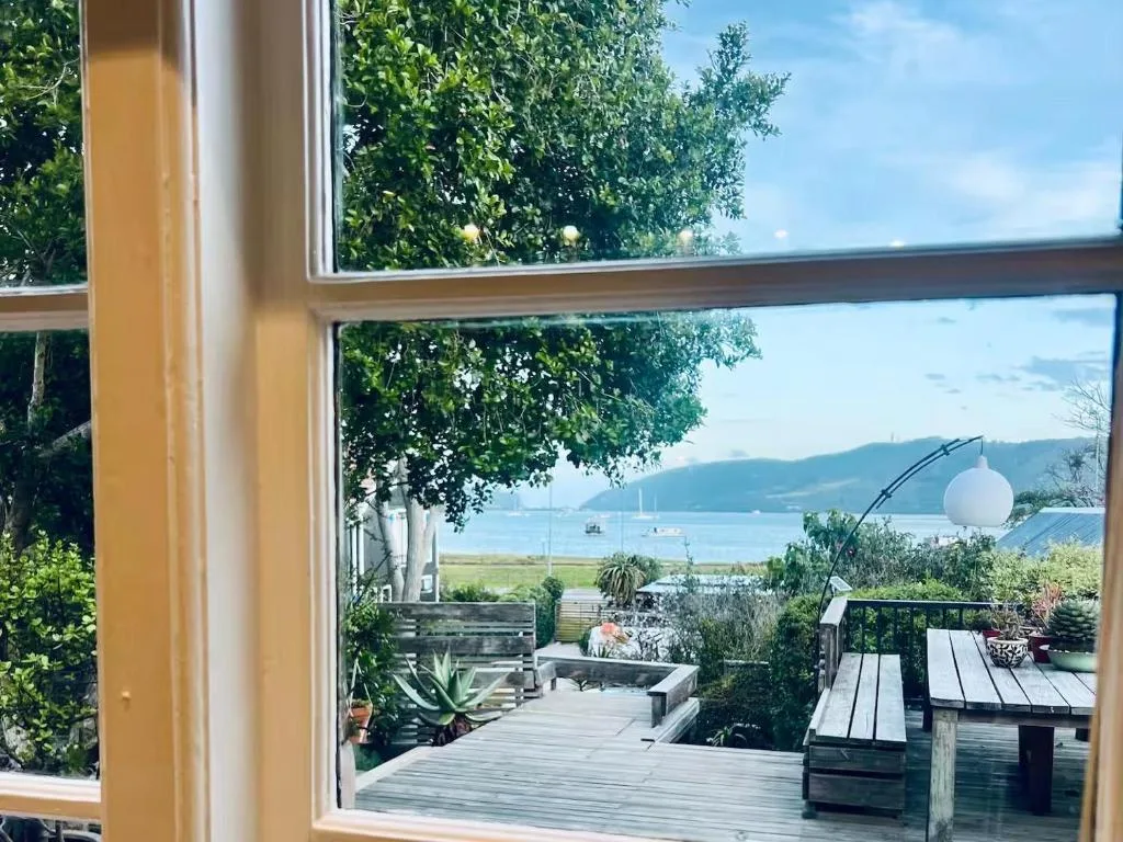 Scenic lagoon and mountain views framed through modern windows and deck