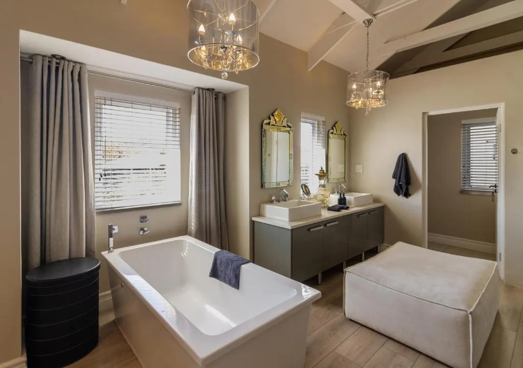 Luxurious bathroom with freestanding bathtub, double vanity, and crystal chandeliers