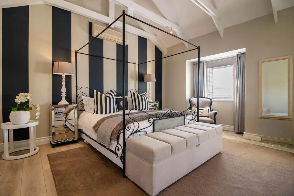 Elegant master bedroom with black four-poster bed and contemporary decor