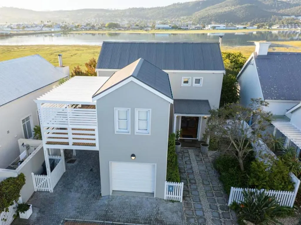 Modern white villa with dark roof overlooking Knysna lagoon and mountains