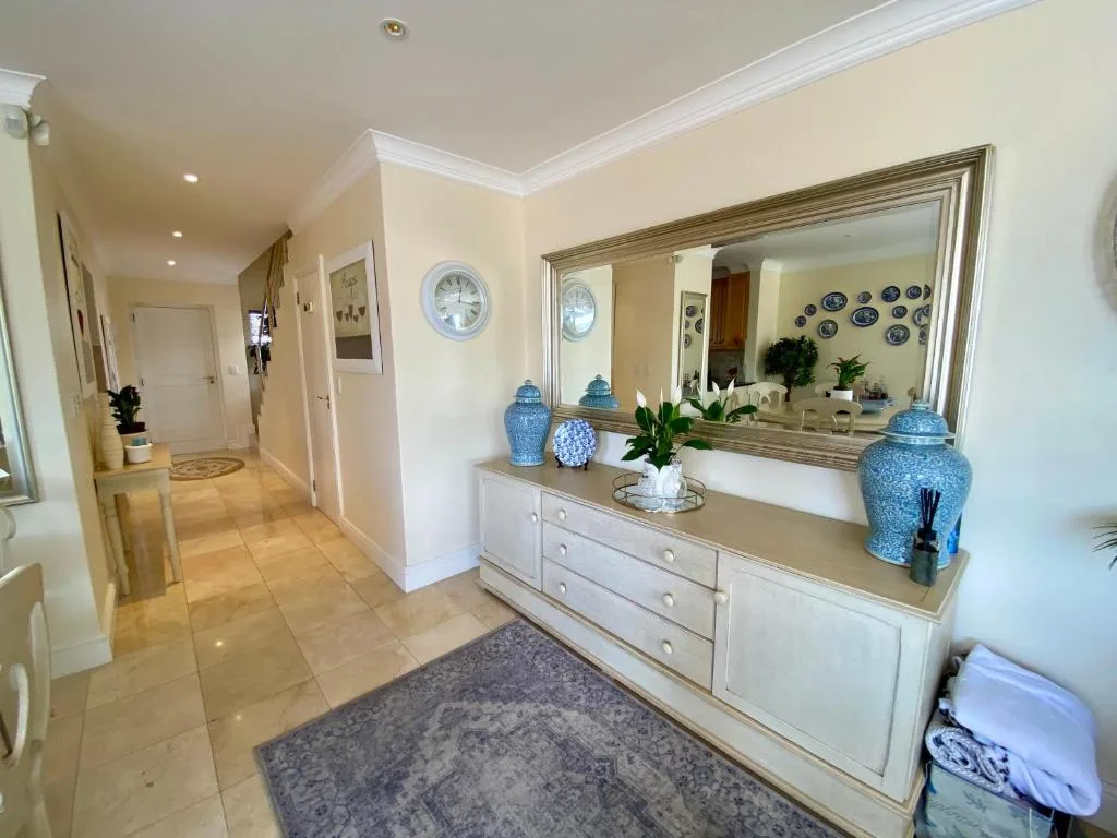 Elegant hallway with white cabinetry, blue ceramic jars, and decorative plates